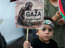 Seorang pengunjuk rasa muda mengangkat plakat selama unjuk rasa yang diserukan oleh penyelenggara Lebanon dan badan pengungsi Palestina untuk mengecam kelaparan yang dialami warga Palestina di Jalur Gaza yang dikepung Israel, di kota pelabuhan Sidon, Lebanon selatan, pada 25 Juli 2025 /AFP