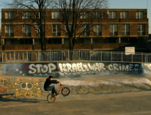  Seorang pesepeda BMX melompati grafiti bertuliskan 