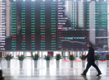 Seorang pria mengenakan masker terlihat di dalam gedung Bursa Efek Shanghai di distrik keuangan Pudong di Shanghai, Tiongkok, 28 Februari 2020 /Reuters