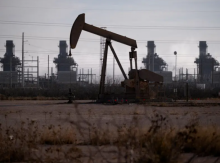 Sebuah pompa dongkrak beroperasi di dekat pembangkit listrik turbin gas di ladang minyak Permian Basin di luar Odessa, Texas, AS, 18 Februari 2025 /Reuters