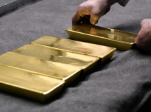 Seorang karyawan menempatkan ingot emas murni 99,99% di ruang kerja di Pabrik Pemurnian & Manufaktur Logam Mulia Novosibirsk /Reuters