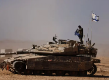 Seorang tentara Israel berdiri di atas tank di sisi perbatasan Israel dengan Gaza, pada 20 Agustus /Reuters