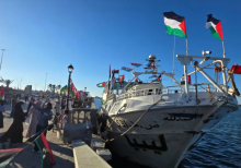 Orang-orang berpose untuk berfoto di depan kapal Omar al-Mukhtar, kapal Libya yang berlayar pada 17 September untuk bergabung dengan Armada Sumud Global, di pelabuhan Tripoli pada 16 September 2025 /AFP