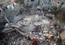 Dalam pandangan udara ini, warga Palestina memeriksa reruntuhan bangunan yang hancur akibat serangan Israel di kamp pengungsi Nuseirat di Jalur Gaza tengah pada 28 September 2025 /AFP