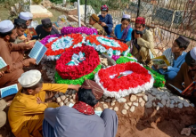 Para pelayat membaca Al-Qur'an sambil duduk di sekitar makam seorang anggota paramiliter Korps Perbatasan (KKP) yang tewas dalam bentrokan perbatasan Afghanistan-Pakistan, di Kohat pada 17 Oktober 2025/ AFP