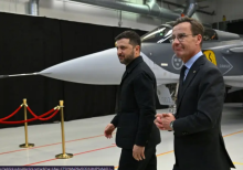 Perdana Menteri Swedia Ulf Kristersson (kanan) dan Presiden Ukraina Volodymyr Zelensky berjalan melewati jet tempur Gripen setelah mereka menyampaikan konferensi pers bersama di Linkoping, Swedia, pada 22 Oktober 2025, setelah pembicaraan mengenai agresi Rusia yang sedang berlangsung terhadap Ukrain