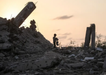 Seorang anak laki-laki Palestina memunguti puing-puing di Nuseirat, Jalur Gaza pada 11 November 2025/ AFP