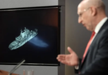 Menteri Pertahanan Inggris John Healey, dengan latar belakang layar yang menampilkan gambar kapal militer Rusia Yantar, yang beroperasi di lepas pantai utara Skotlandia, menyampaikan pidato di ruang pengarahan Downing Street di London pusat pada 19 November 2025/ AFP