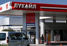 Seorang pria berdiri di sebuah SPBU milik perusahaan energi raksasa Rusia, Lukoil, di Sofia pada 23 Oktober 2025/ AFP